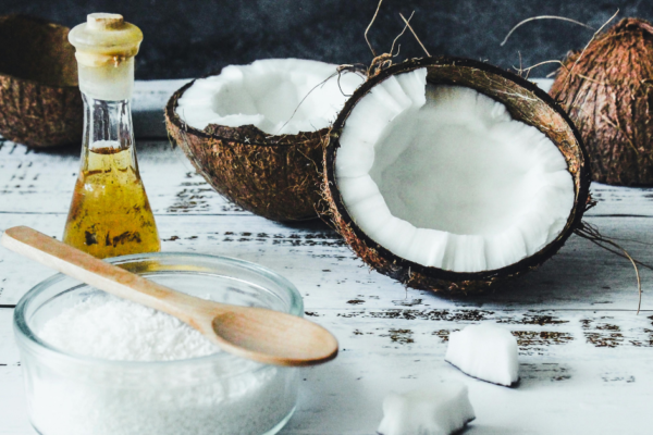 Parachute coconut oil for hair growth natural coconut treatment with fresh coconut and oil on wooden table