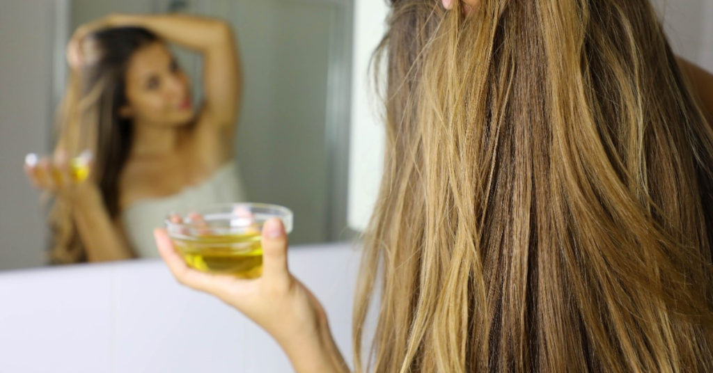Woman applying Swastik Castor Oil for Hair as part of a weekly natural hair care routine