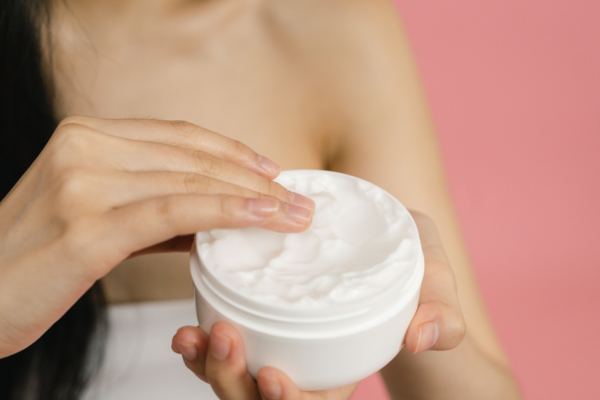 Woman applying cream for dry scalp to moisturize dry areas