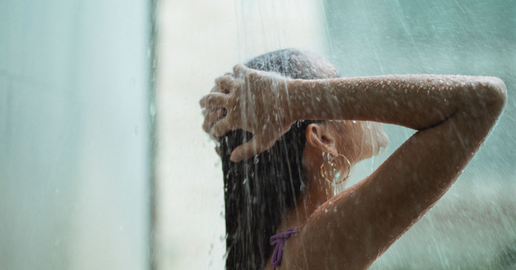 Woman washing hair as part of a gentle cleansing routine